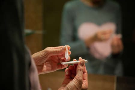 Dropping testing saline solution on a control stick of a home self covid19 test in a conceptual image of quarantine and pandemic.の写真素材