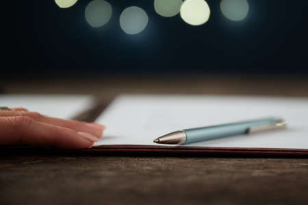 Low angle view of a pen lying on document, contract or application form in a folder.の写真素材