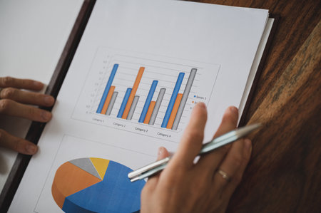 High angle closeup view of female entrepreneur looking through a business paperwork report with...