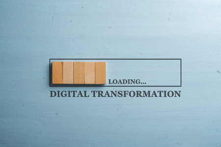 Progress bar cut into a blue wooden background with wooden blocks representing the progress loading with a Digital transformation sign under it.の写真素材