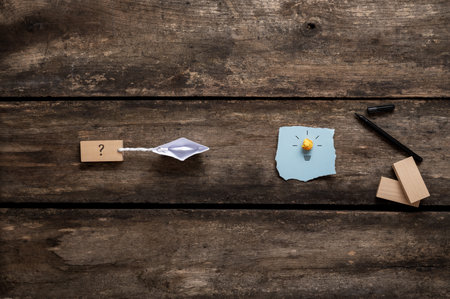 Conceptual image of business vision and idea and the way to the goal - origami made paper boat pulling a question mark sign towards a lightbulb.の写真素材