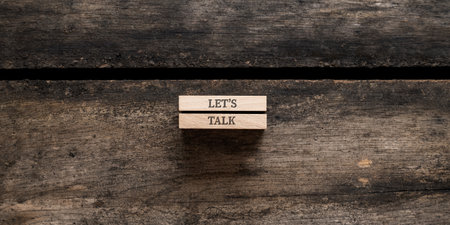 Lets talk sign written on two wooden pegs placed on rustic wooden background.の写真素材