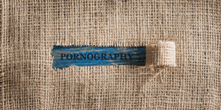 Top view of a rough linen fabric with a torn window in the middle with a Pornography word written in it.の写真素材