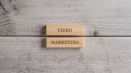 Video marketing sign written on a stack of two wooden pegs placed on plain simple white wooden background.の写真素材