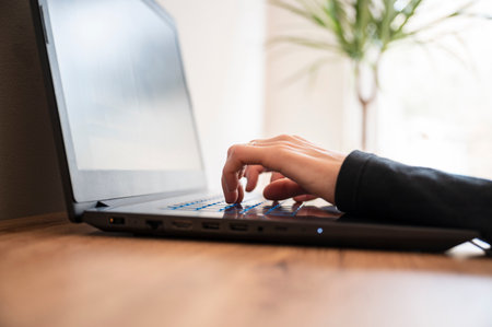 Low angle view of female hands using and typing on laptop computer.の写真素材