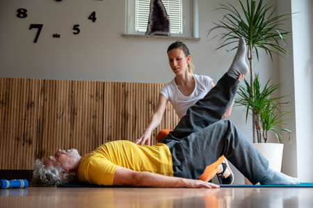 Young physiotherapist working with a senior man to teach him the right position and exercise for back and core strength.の写真素材