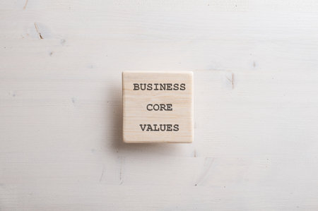 Wooden tile with a Business core value sign on it placed over simple plain wooden background.の写真素材