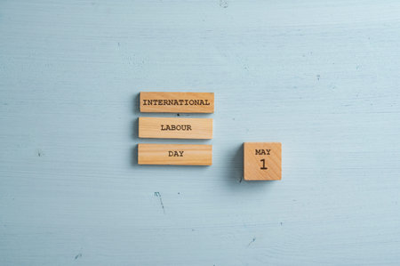International labour day May 1 sign written on wooden pegs. Over light blue wooden background with copy space.の写真素材