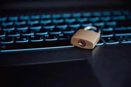 Golden padlock lying on a laptop computer keyboard jn a conceptual image of online safety and data protection. Closeup view.の写真素材