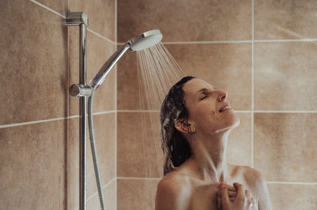 Young woman enjyoing a hot shower after a long day. Water running on her shampooed hair.