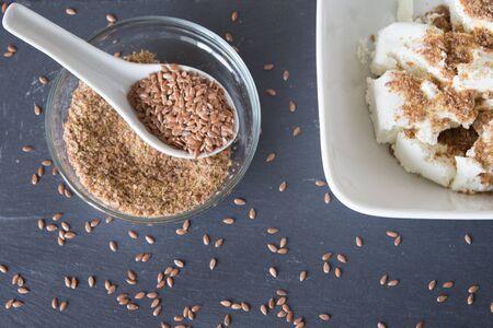 Homemade cottage cheese cream with crushed flax seeds on stone background. Top viewの写真素材