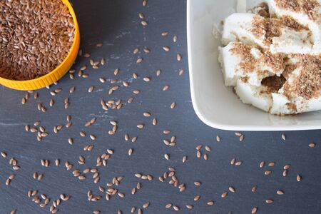 Homemade cottage cheese cream with crushed flax seeds on stone background. Top viewの写真素材