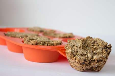 Bread from rye flour with seeds in silicone orange bakeware white backgroundの写真素材