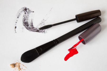Makeup brush, red nail polish and mascara on white backgroundの写真素材
