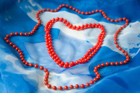 heart of beads on a background of blue silkの写真素材