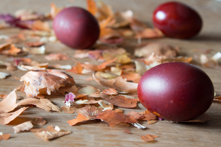 Eggs, painted with onion husks. Easter eggs and onion husks. Wooden boardの写真素材
