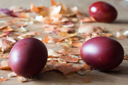 Eggs, painted with onion husks. Easter eggs and onion husks. Wooden boardの写真素材