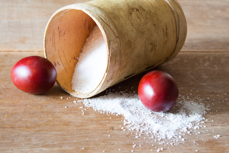 Easter eggs, painted with onion husks. A box of birch bark with salt. Indoors, wooden tableの写真素材