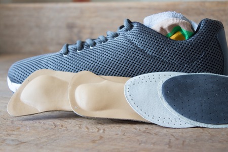 Gray running shoes with orthopedic insoles. Wooden boardの写真素材