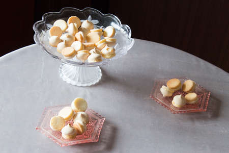 Vase with cookies on a round table. Pink shallow decorative dish with biscuits.の写真素材
