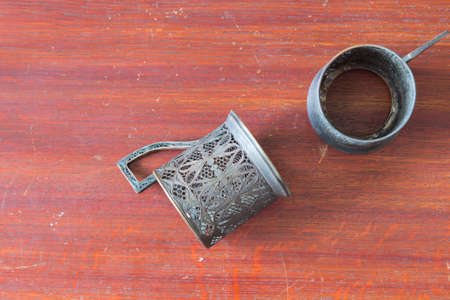 two old metal cup holder on old wooden table in  old house.の写真素材
