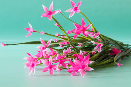 Pink flowers made of artificial material. Neutral green background.の写真素材