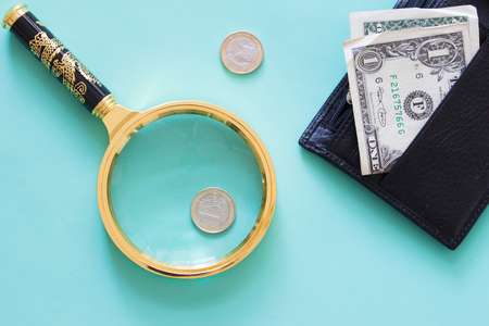 Magnifying glass and money on a neutral green background. ?op view.の写真素材