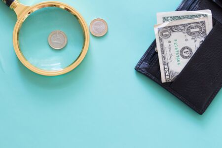 Magnifying glass and money on a neutral green background. ?op view.の写真素材