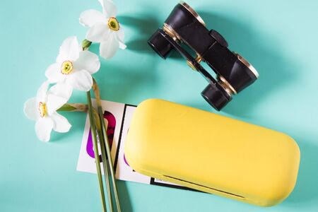 Black binoculars, narcissus flowers, eye glasses case and theater tickets. Trip to the theater. Top view. Neutral backgroundの写真素材