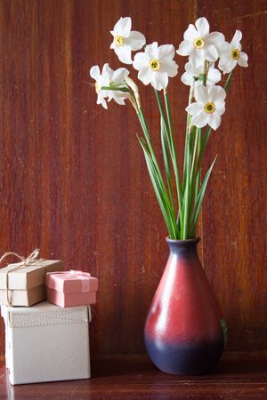 Bouquet of white daffodils in a ceramic vase. Romantic gifts. Spring Flowers. Narcissus on wooden background.の写真素材