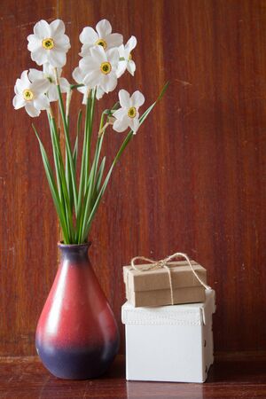 Bouquet of white daffodils in a ceramic vase. Romantic gifts. Spring Flowers. Narcissus on wooden background.の写真素材