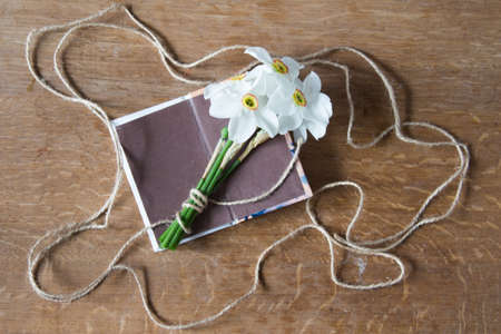 White daffodils bouquet on wooden background. Narcissus flowers and notebook. Romantic gift.の写真素材