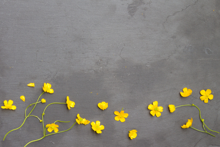 Floral frame made of buttercups on stone. Yellow flowers. Floral background. Top view.の写真素材