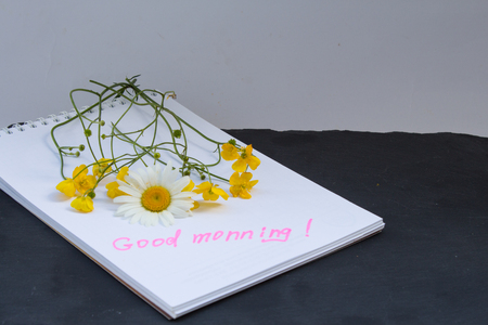 Bouquet of flowers buttercups and chamomiles and notes good morning on stone. Top view.の写真素材