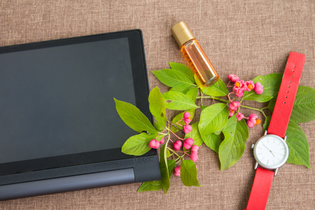 Tablet computer with flowering branch, wrist watch and perfumes.の写真素材
