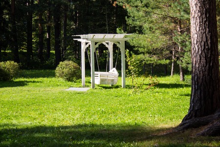 Exquisite white swing in the garden. Use for relaxation or decorate for weddings.の写真素材