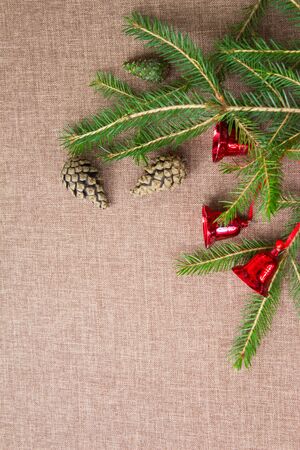 Corner made of green spruce branches with red bells and fir cones. Top view.の写真素材