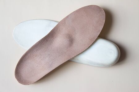 Leather orthopedic insoles for footwear on beige backgroundの写真素材