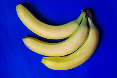 Bunch of bananas isolated on blue background. Top viewの写真素材