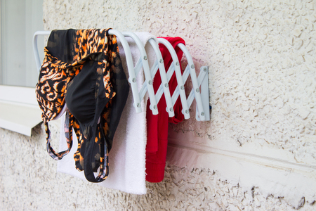 Clothes horse on the balcony. Drying colorful clothes.の写真素材