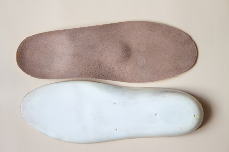 Pair beige orthopedic shoe insoles isolated on cream backgroundの写真素材