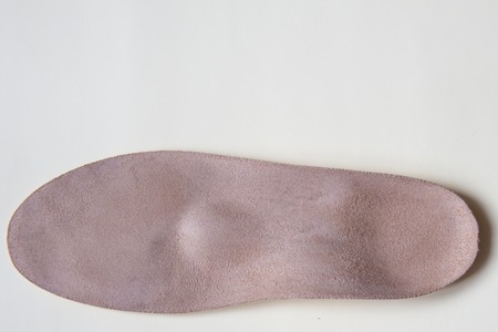 Leather orthopedic insole for footwear on cream backgroundの写真素材