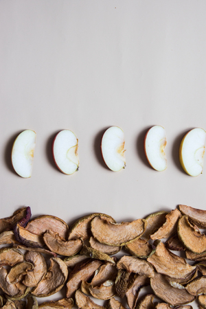 Homemade dried organic apple slices with fresh apple chips on beige background. Top view.の写真素材