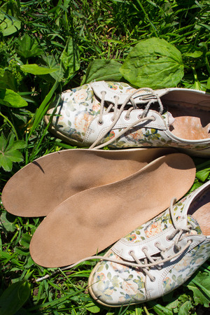 Leather orthopedic insoles with running shoes on the grass. Healthy relax on nature. Outdoors.の写真素材