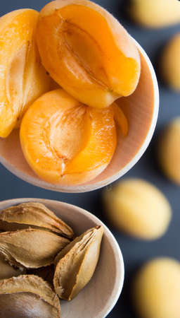 Apricot halves and kernels in wooden spoons. Top view.の写真素材