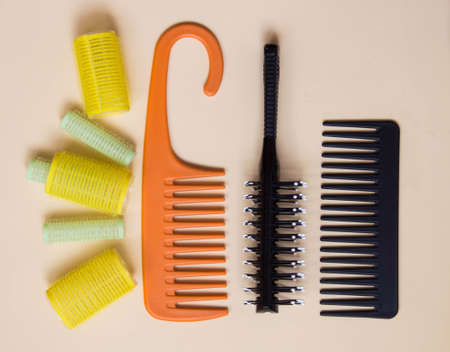 Green yellow curlers, combs, hair brush. Hair care concept. Pastel background. Top viewの写真素材