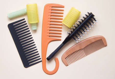 Green yellow curlers, combs, hair brush. Hair care concept. Pastel background. Top viewの写真素材