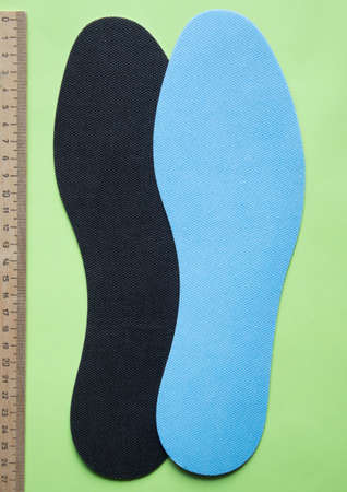 Insoles for shoes with ruler on green background. Top view.