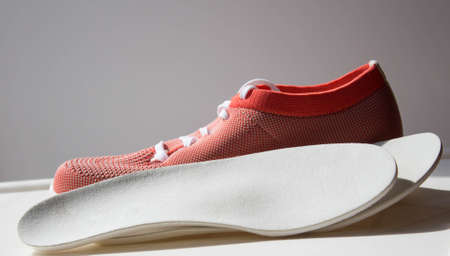 Leather orthopedic insoles located near the sport shoe with orthopedic sole. Treatment and prevention of flat feet and foot diseases.の写真素材