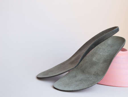 Leather orthopedic insoles on neutral background. Prevention and treatment of flat feet. footcare.の写真素材